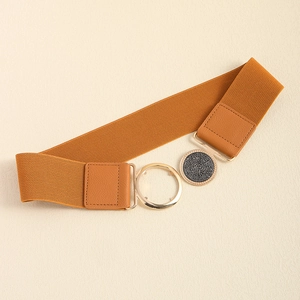 Detail of a brown elastic waist belt with a golden round metal buckle and glitter inlay