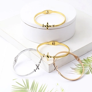 Vue détaillée des bracelets avion en or, argent et or rose avec incrustation d'émail