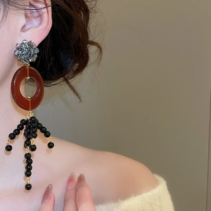 Detail view of crystal tassel earrings with grey druzy studs and black bead fringes