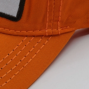 Close-up of orange cotton baseball cap showing double stitching and embroidery detail