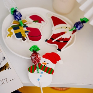 Macro shot of cute Santa and Snowman paper cards for DIY lollipop decoration