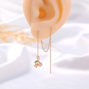 Macro detail of gold cherry ear threaders with pink crystal stones and green leaf charm