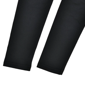 Gros plan détaillé montrant l'ourlet à double couture précise sur le tissu élastique noir