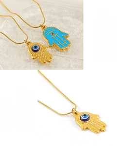 Detailed close-up of golden Hamsa Hand pendants with evil eye inlay on snake chains
