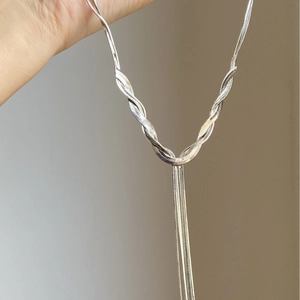 Detail of silver snake chain necklace with a unique knot and long tassel fringe design