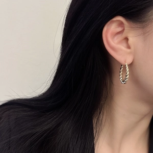 French vintage gold twisted hoop earrings worn by a model in a minimalist style