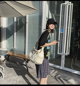 Outdoor shot of a white canvas messenger bag being worn for a casual lifestyle look