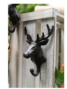 Macro shot of rustic cast iron stag head hook showing vintage texture and antler detail
