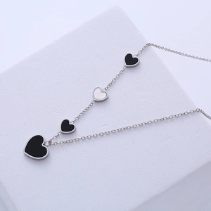 Elegant stainless steel necklace with black and white heart pendants on silver chain
