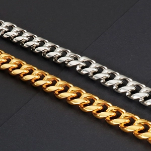 Close-up of high-polished gold and silver 15mm cuban link chains on black background