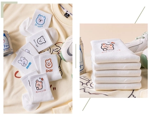 Detail of white cotton socks with cute cartoon bear patterns and happy slogans