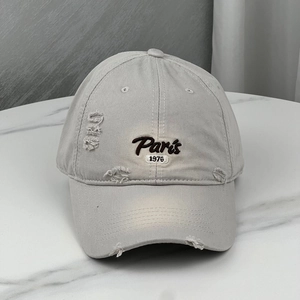 Detail of distressed embroidery on vintage beige cotton baseball cap with Paris 1976 design