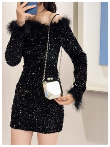 Detail view of sparkly black sequin dress featuring elegant feather trim and slim fit design