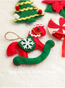 Macro shot of assorted felt Christmas ornaments like rocking horse and tree on white fur