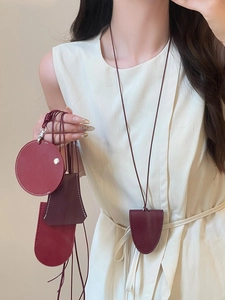 Detail of red faux leather magnetic glasses holder necklace and small storage pouches