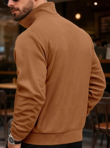 Detailed view of warm brown ribbed knit texture on a men's long sleeve turtleneck sweater