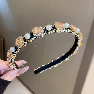 Close-up of vintage champagne gems and white pearls on a gold alloy headband