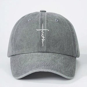 Close-up of white faith cross embroidery on washed grey cotton baseball cap