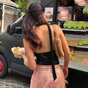 Detailed back view of a black lace halter top featuring open back and tie-up ribbon design
