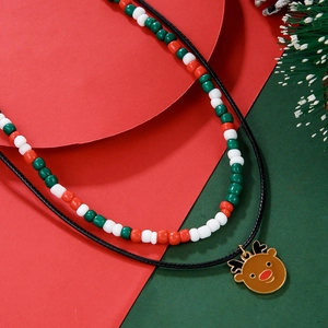 Detail of double-layer Christmas necklace with red green beads and golden reindeer pendant