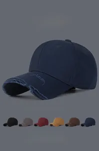 Detailed view of distressed baseball cap brim showing frayed edges and vintage cotton texture