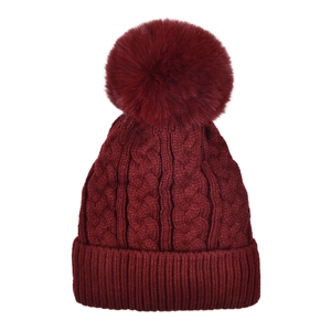 Close-up of cable knit pattern and large faux fur pompom on burgundy winter beanie