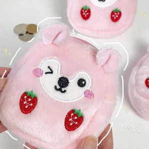 Close-up of pink plush coin purse with embroidered winking bear and strawberry motifs