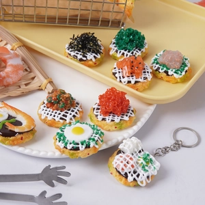 Varietà di ciondoli alimentari realistici con polpette di gamberi e sushi su un vassoio