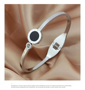 Detail view of silver titanium Roman numeral bangle with black shell inlay on silk