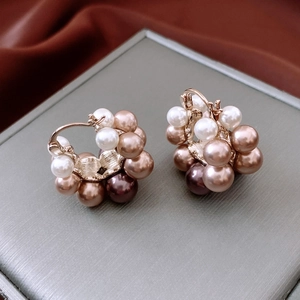 Close-up of vintage pearl hoop earrings with white and champagne cluster pearls