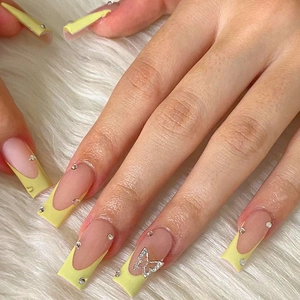 French bow press-on nails in pale yellow with 3D silver butterfly and small rhinestones
