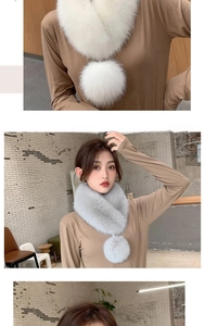 Detail of light gray faux fur neck warmer with pompom accent on a stylish camel knit sweater