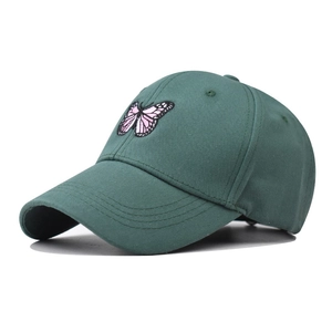 Gros plan de la broderie papillon sur une casquette en coton vert foncé