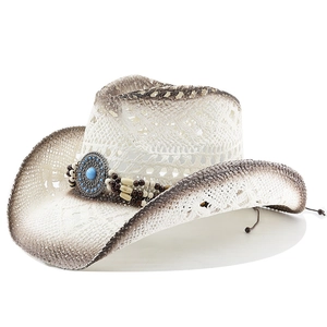 Handwoven straw cowboy hat featuring ethnic beaded band and turquoise metal emblem