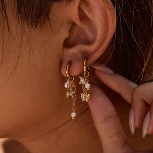 Boucles d'oreilles asymétriques dorées avec perles, étoile, papillon et chaîne longue