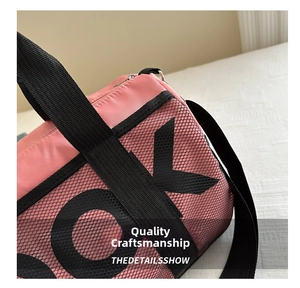 Detail of pink and black mesh sports bag with durable woven handles and letter print