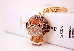 Macro detail of cute alloy monkey keychain with glittering brown and gold rhinestones