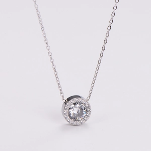 Macro shot of a silver necklace featuring a sparkling round pendant with halo stones