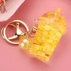 Detail of creative lemon tea keychain with yellow fruit slices and golden lobster clasp