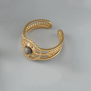 Detailed view of bohemian gold hollow ring with round natural grey stone inlay