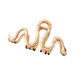 Minimalist snake-shaped gold metal hair claw clip with a polished finish on white background