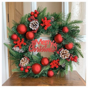 Detailaufnahme vom Weihnachtskranz mit Tannennadeln, roten Beeren und Merry Christmas