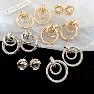 Détails de diverses boucles d'oreilles dorées et argentées aux finitions texturées