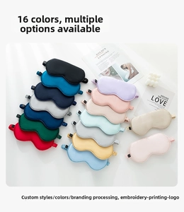 Detail showing 16 colors of 22mm silk sleep masks with elastic headbands on a white desk