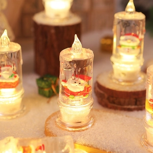 Close-up of LED Christmas candle lamp with Santa figurine and warm glowing water light