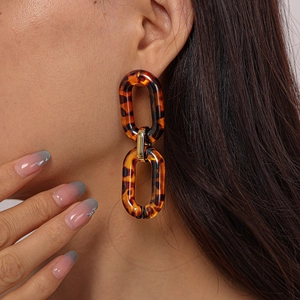 Detail of tortoise shell acrylic linked earrings with golden metallic connectors