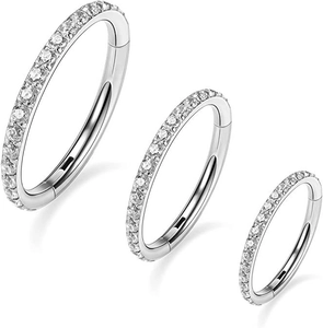 Macro view of three sizes of silver 316L stainless steel hinged rings with pave zircon crystals