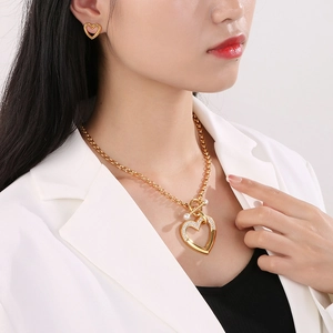 Détail du parure collier et boucles d'oreilles cœur doré avec pavé de cristaux et perle