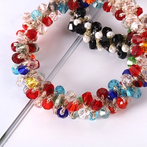 Detailed close-up of woven crystal beads and pearls on elastic spiral hair ties