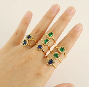 Detail of hand wearing stacked 18K gold stainless steel rings with colorful zircons